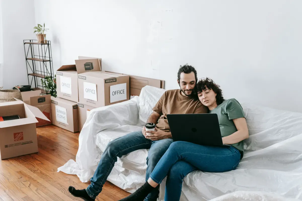 Couple resting on a sofa among moving boxes