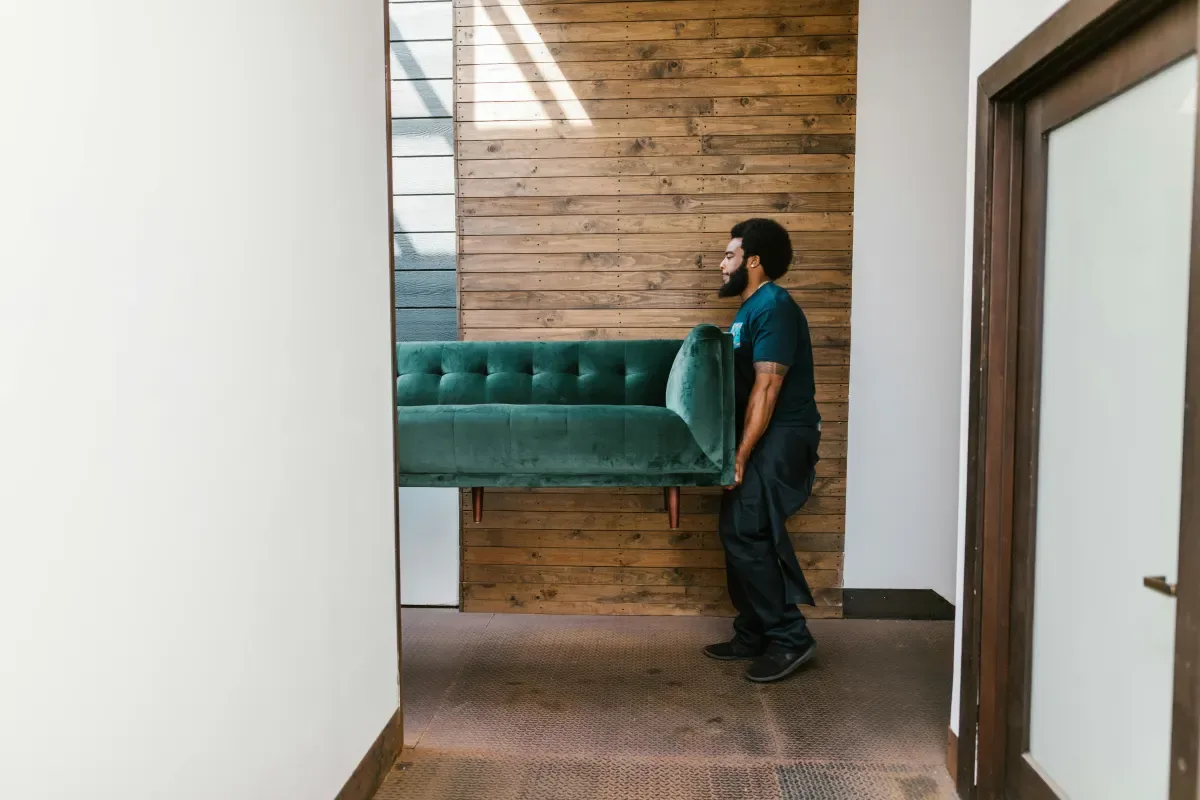 Mover carrying a heavy table through a doorway