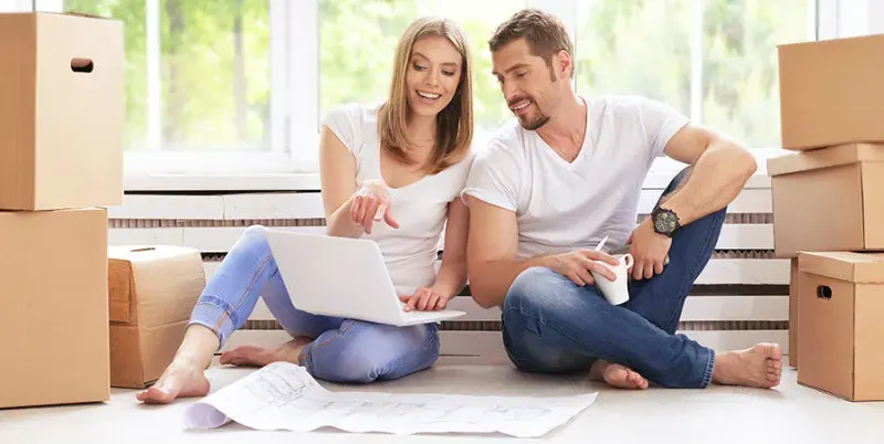 Couple planning a move beside packed boxes