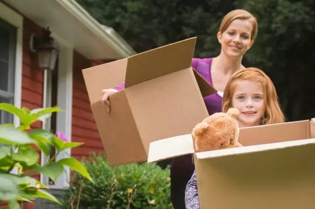 Adult and child carrying boxes together